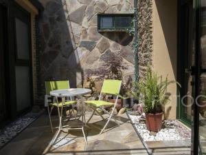 patio ze stołem i krzesłami oraz kamienną ścianą w obiekcie Pension Siete en el Camino w mieście Sarria
