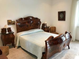 um quarto com uma cama grande e uma cabeceira em madeira em Villa Valentina em Taranto