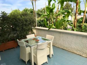 een glazen tafel en stoelen op een patio bij Villa Valentina in Taranto