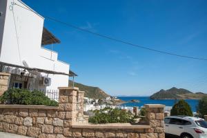 a white house with a view of the ocean at Captain Manos Studio Apartments in Grikos