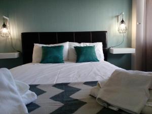 a bedroom with a large bed with two blue pillows at Apartamento Ocean Dreams in Quarteira