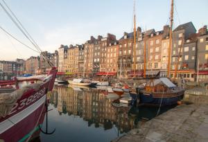 un gruppo di barche attraccate in un porto con edifici di Honfleur location a Honfleur Altre 14 foto