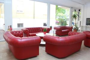 a waiting room with red leather chairs and a table at Hotel Stella Polare in Rimini