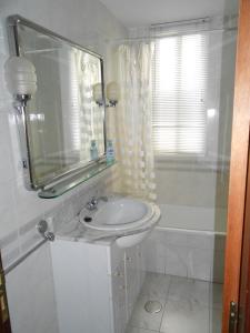 W łazience znajduje się umywalka, lustro i wanna. w obiekcie San Blas w mieście Santa Marta de Tormes