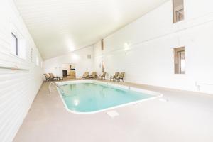 una gran piscina cubierta en una habitación blanca con sillas en Teton West Motel en Driggs