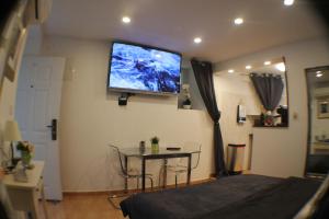 a bedroom with a tv on the wall and a table at Amorino Apartman Studio in Opatija