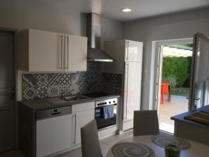 a kitchen with white cabinets and a sink and a table at Sainte Maxime 4 pièces in Sainte-Maxime