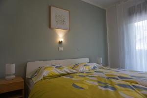um quarto com uma cama com um cobertor amarelo e azul em Apartma Irena Volče em Volče