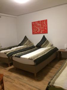 2 Betten in einem Zimmer mit Wandgemälde in der Unterkunft Abels Appartements in Bochum