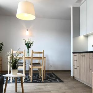 cocina y comedor con mesa y sillas en Apartamenty Nadmorska, en Rowy