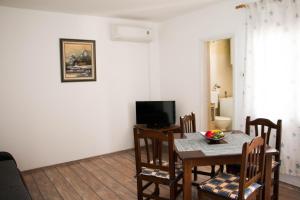 a dining room with a table and a television at Sunshine in Cavtat