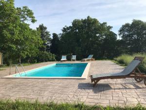 a swimming pool with two chairs and a bench at Villa Bellevue in Vižinada