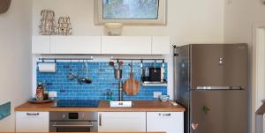 uma cozinha com armários brancos e um frigorífico em Blue Bay Taormina em Taormina
