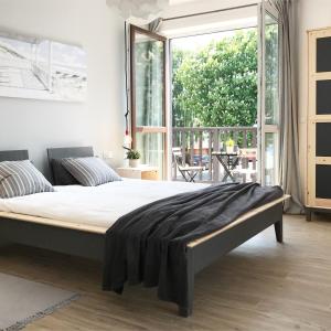 1 cama en un dormitorio con ventana grande en Apartamenty Nadmorska, en Rowy