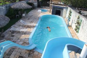 een vrouw die over een glijbaan in een zwembad zwemt bij Solar das Gaivotas Pousada in Barreirinhas