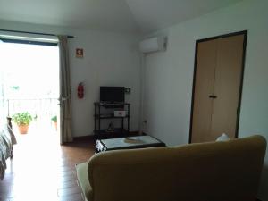 a living room with a couch and a television at Residencial Retiro Sra. da Luz in Ponte de Lima
