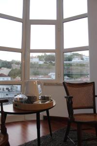 a room with a table and chairs and windows at AL embaixador in Alenquer