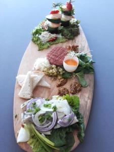 a wooden cutting board with sandwiches and vegetables on it at Hotel Inner City in Kutno