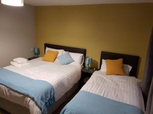 Duas camas sentadas uma ao lado da outra num quarto em Lynch's on the Pier em Castletownbere