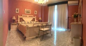1 dormitorio con 1 cama y 1 silla en Hospedium Hotel Twist, en Torredonjimeno