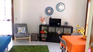 a living room with a tv and a chair and a table at Foz do Arelho Beach Apartment "Blue" in Foz do Arelho