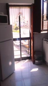 フォス・ド・アレーリョにあるFoz do Arelho Beach Apartment "Blue"の窓につながるドア付きのキッチン