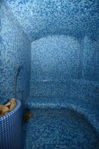 a blue tiled bathroom with a tub in a room at Hotel Adria in Biograd na Moru