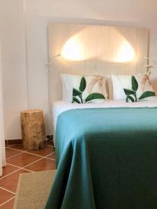 エリセイラにあるEriceira Boutique Apartment - byEMEのベッドルーム1室(緑の毛布付きのベッド1台付)