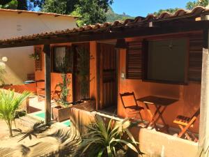 a patio of a house with a table and a television at Casa Aluguel Abraão 3,Ilha grande in Abraão