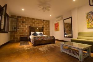a living room with a bed and a brick wall at Casa Del Reloj in Medellín
