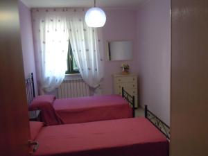 a small room with two beds and a window at Villa Rosangela in Agropoli