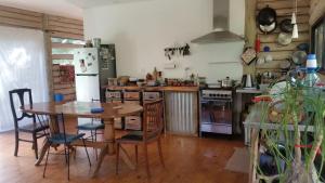 a kitchen with a wooden table and a kitchen with a refrigerator at Chalet Los Troncos in Sauce de Portezuelo