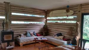 a room with wooden walls with a couch and a table at Chalet Los Troncos in Sauce de Portezuelo +7 photos