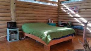 1 dormitorio con 1 cama en una cabaña de madera en Chalet Los Troncos, en Sauce de Portezuelo