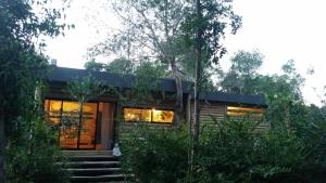 a house with a cat sitting outside of it at Chalet Los Troncos in Sauce de Portezuelo