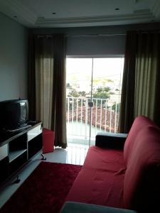 a living room with a red bed and a television at Sobrado na Cidade de Socorro in Socorro