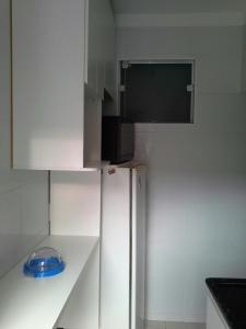 a white kitchen with a refrigerator and a microwave at Sobrado na Cidade de Socorro in Socorro +19 photos