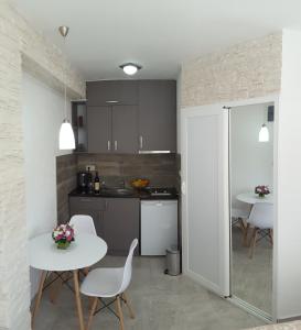 a kitchen with a table and two tables and chairs at Apartments "4You" in Tivat