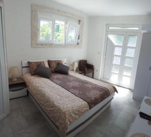 ein Schlafzimmer mit einem großen Bett und zwei Fenstern in der Unterkunft Apartments "4You" in Tivat