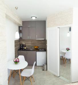 una cocina con mesas blancas y sillas blancas en una habitación en Apartments "4You", en Tivat