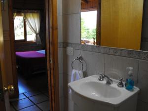 W łazience znajduje się umywalka i lustro. w obiekcie Cabañas San Valentin w mieście Lago Puelo