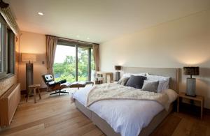 een slaapkamer met een groot bed en een groot raam bij Akatsuki in Niseko