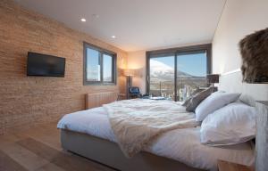 a bedroom with a large bed with a brick wall at Akatsuki in Niseko