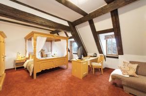 a bedroom with a bed and a desk with a television at Hotel Altes Brauhaus garni in Rothenburg ob der Tauber