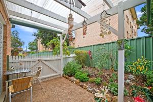 a pergola with a table and chairs in a garden at 354 Owen Street Port Macquarie in Port Macquarie