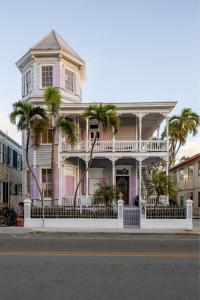 una casa rosa con palmeras delante en The Artist House, en Key West