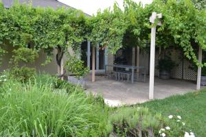 a pergola with a bench in a garden at Tin House in Tanunda in Tanunda