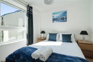 グラスゴーにあるCity Choice G5 Apartmentのベッドルーム1室(白いベッド1台、青い枕、窓付)