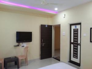 Uma TV ou centro de entretenimento em Maharaja Home Stay Panhala