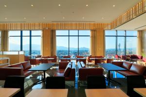 un ristorante con tavoli, sedie e finestre di Candeo Hotels Nara Kashihara a Kashihara
